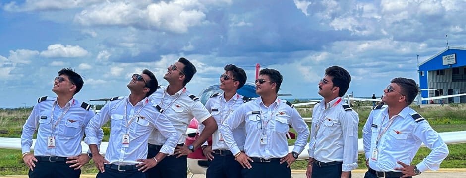 Group of male student pilots posing in front of aircraft